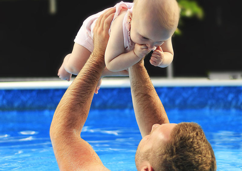 niño en piscina con papa