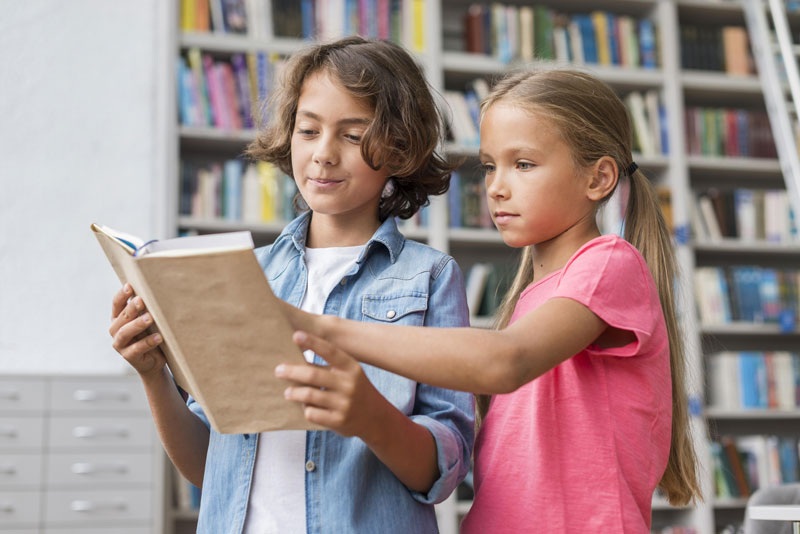 dos niños leyendo libros