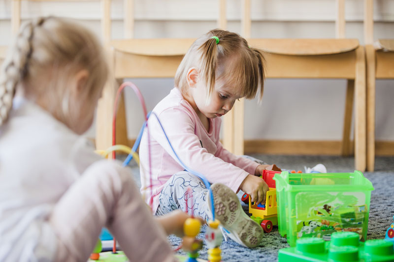 niña jugando con figuras en guarderia