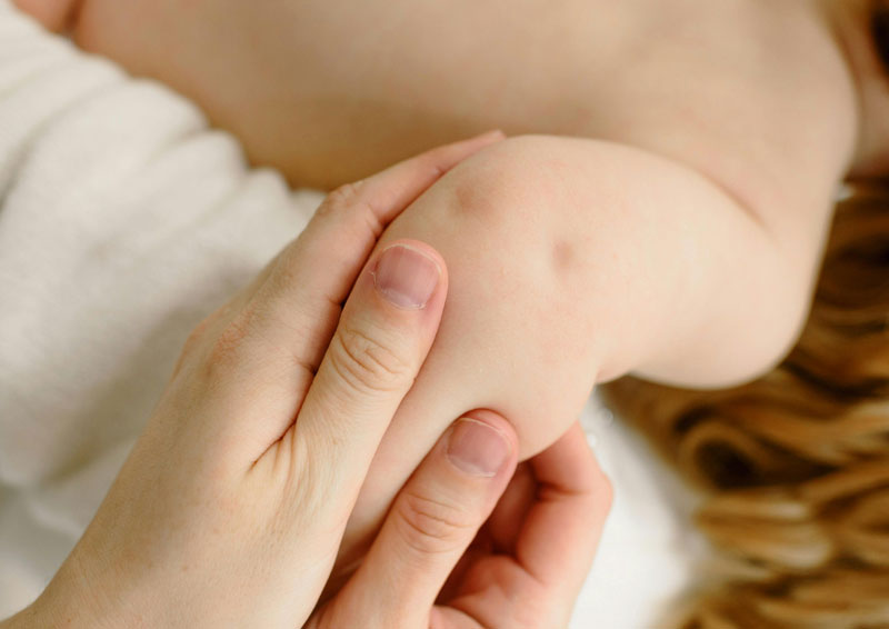 madre cuidando la piel del brazo de su hijo