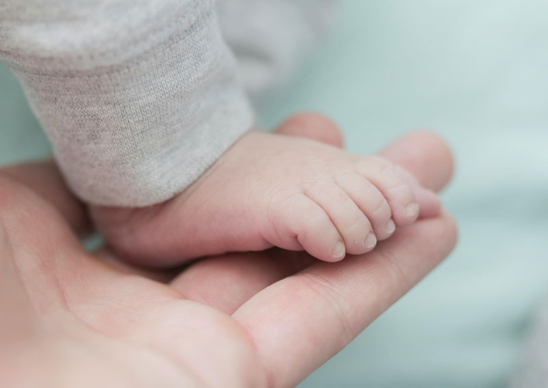 madre cuidando la piel de los pies de su hijo

