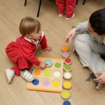 niño jugando a juegos Montessori con su profesora