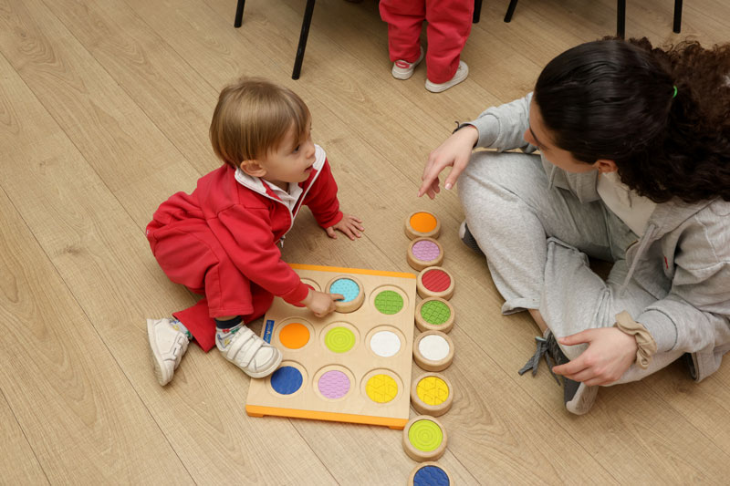 niño jugando a juegos Montessori con su profesora