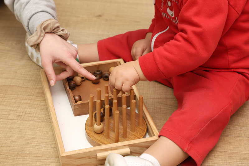 niño jugando a juegos Montessori